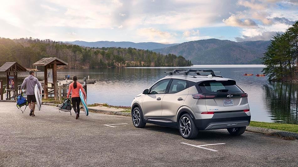 Woman plugging in electric vehicle at a charging station